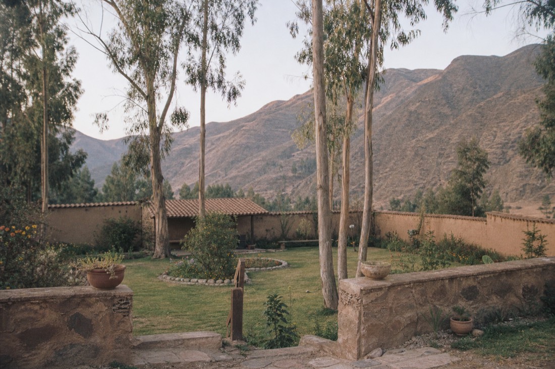 Small retreat garden with adobe walls and eucalyptus trees against Andean foothills